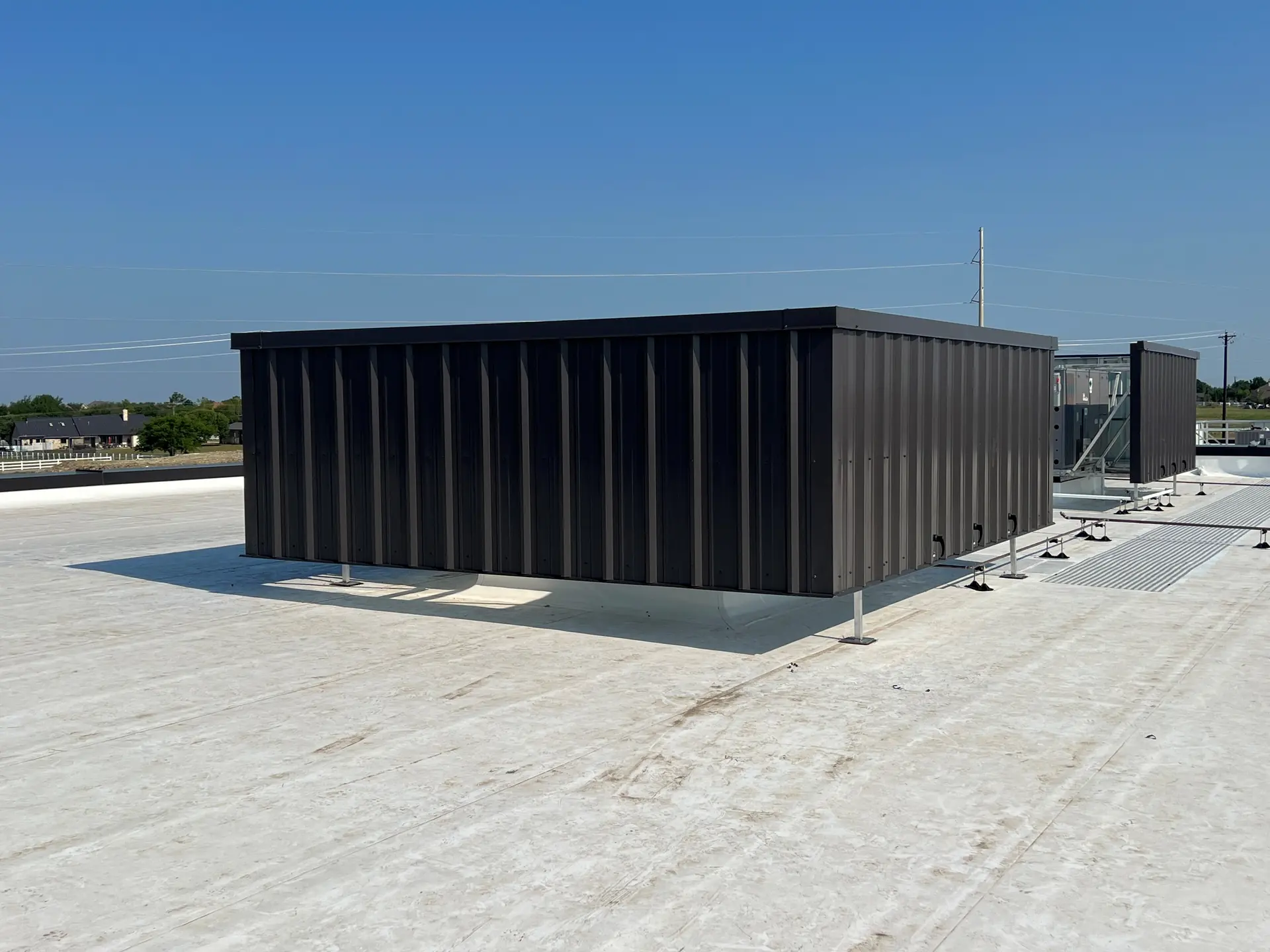Custom steel mechanical equipment screen enclosing rooftop HVAC on a commercial roof